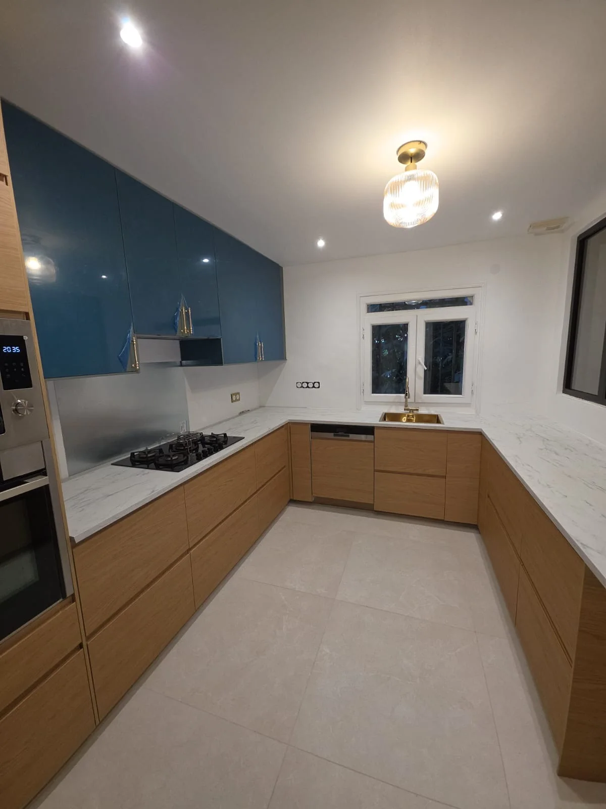 La même cuisine vue depuis l'entrée de la pièce, avec la colonne four et l'évier sous la fenêtre