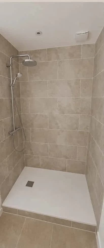 Douche rénovée après travaux, habillée d'une faïence grand format beige, avec receveur extra-plat blanc