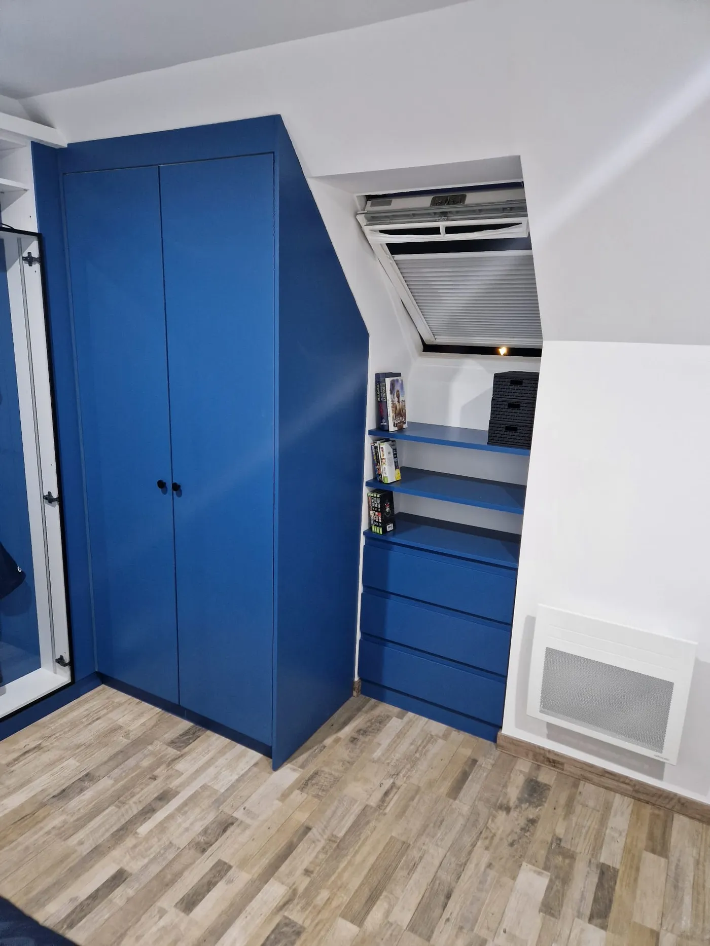 Espace mansardé optimisé par des rangements sur mesure suivant la pente du toit à Juvisy