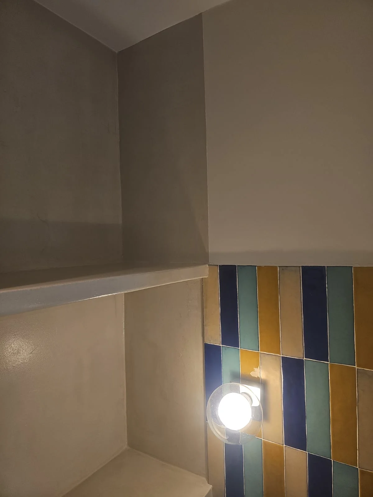 Le banc de douche vu sous un autre angle, avec l'applique posée sur le zellige